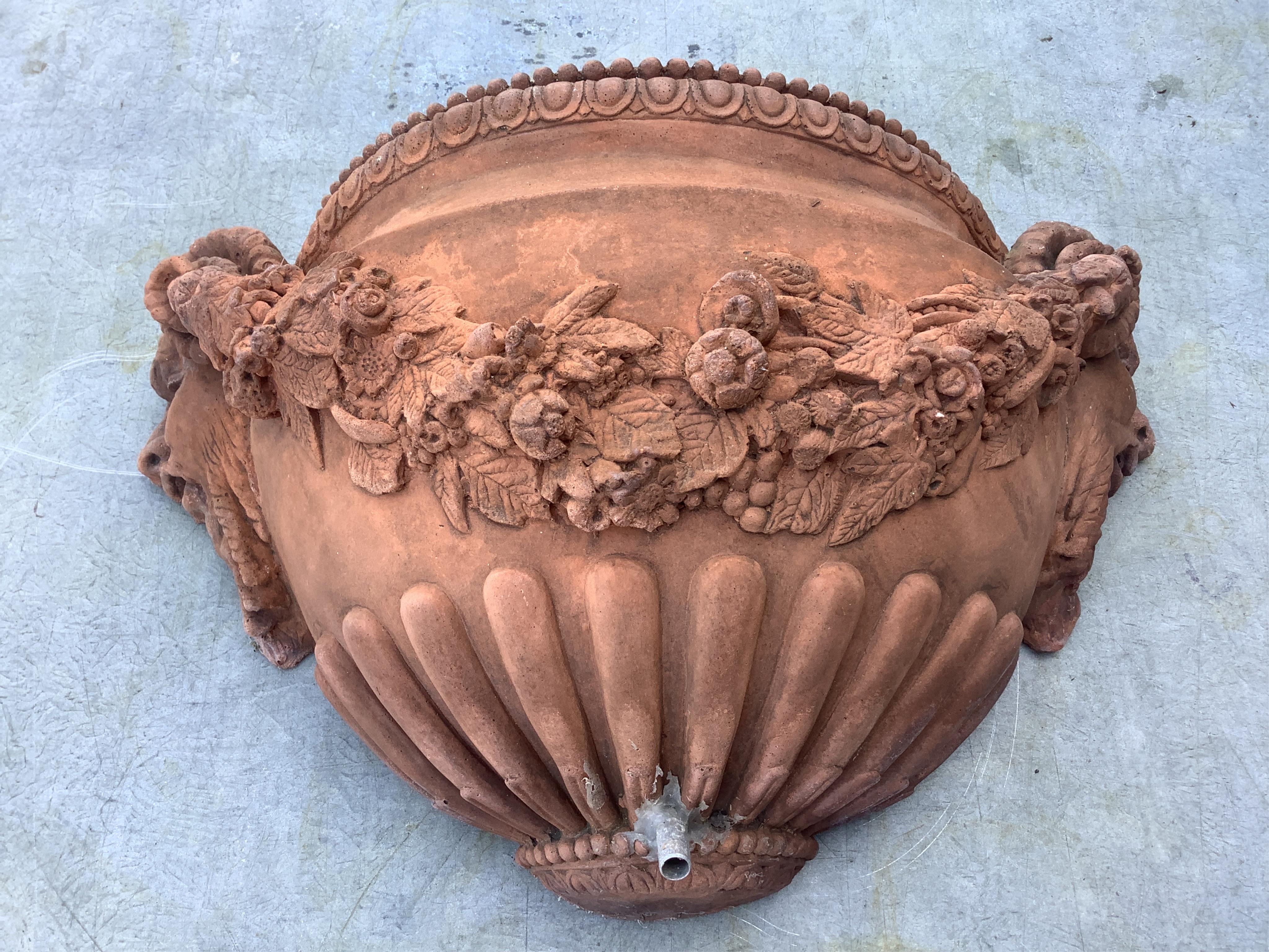A pair of terracotta wall pocket garden fountains, width 46cm, depth 16cm, height 27cm